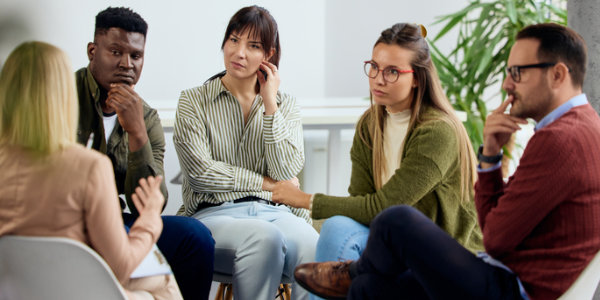  Five people participate in a meaningful group discussion.