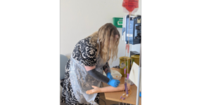 Student nurse practising drawing blood from a plastic arm