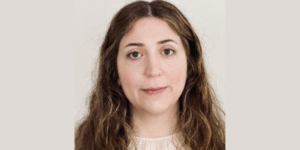 Lady with small smile with a cream background