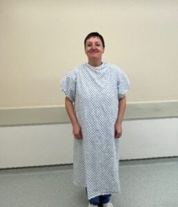 A person stood in a hospital gown