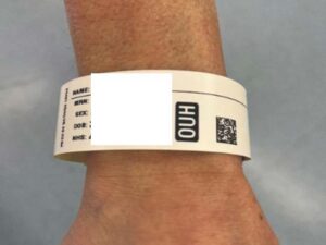 A hospital name wrist band being worn