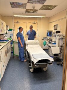 Hospital staff stood next to a bed